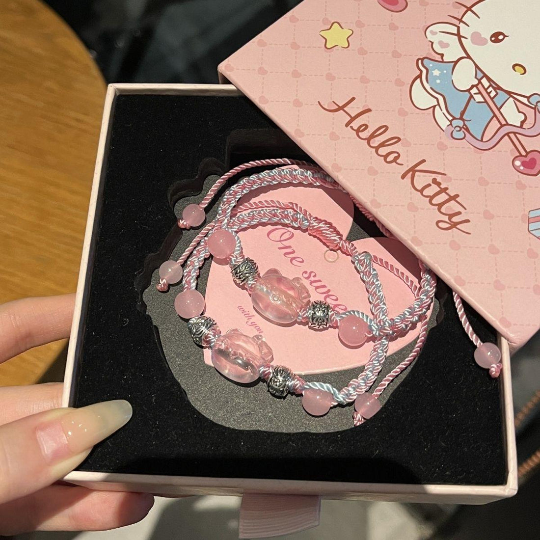 Pink layered braided bracelet set with beads and charms in a decorative gift box