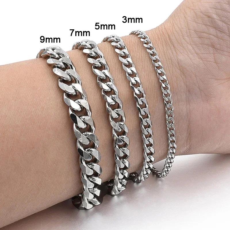 Silver-toned chain necklaces in four different widths styled on a wrist