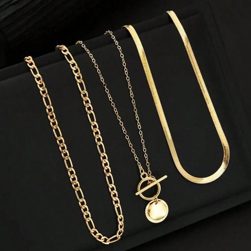 Versatile gold-tone necklaces arranged on a black jewelry stand