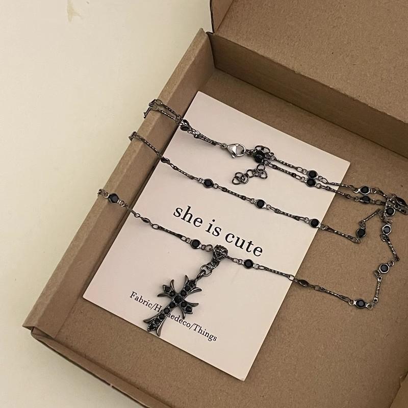 Layered dark-toned necklace with a decorative pendant displayed in a gift box