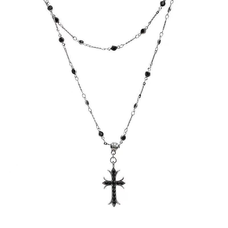 Layered silver-tone necklace with dark accents and a decorative cross pendant